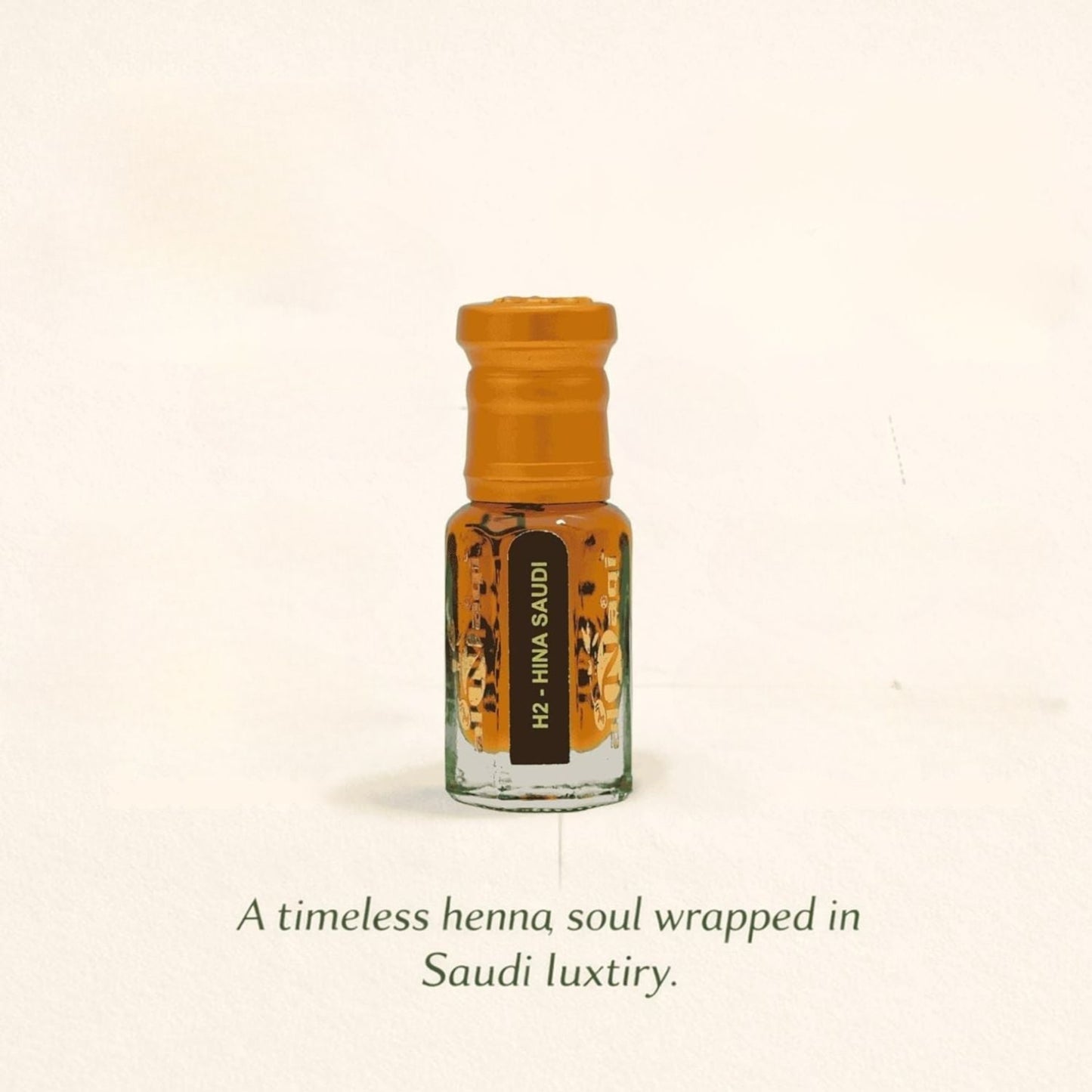 Small glass bottle with an orange cap on a beige background, featuring text about henna and Saudi luxury.