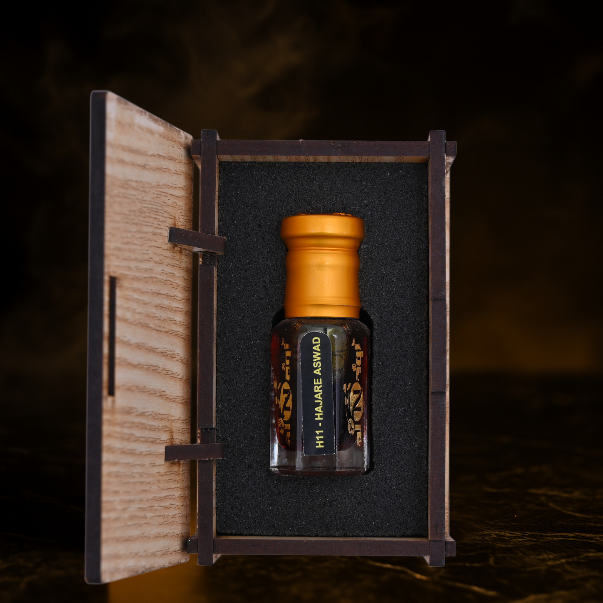 Small bottle with a gold cap in a wooden box on a dark background