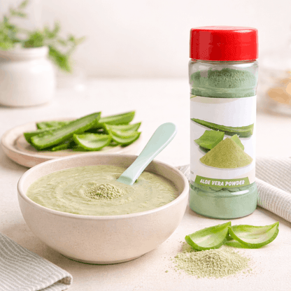 Bowl of aloe vera juice with a bottle of aloe vera powder on a light surface.