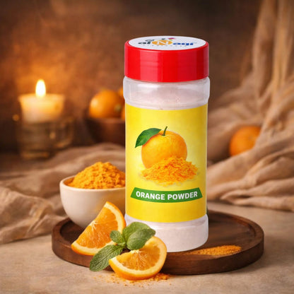 Container of orange powder with a yellow label on a wooden surface with oranges and a candle.