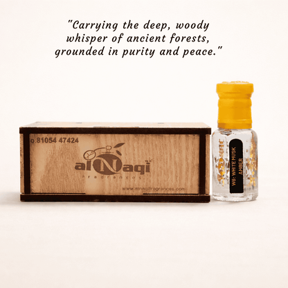 Small bottle with yellow cap and wooden box labeled 'alNagi' on a tree stump with a blurred green background