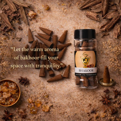 Bakhoor cones and a bottle of Bhakoor incense on a textured surface with star anise and amber pieces.
