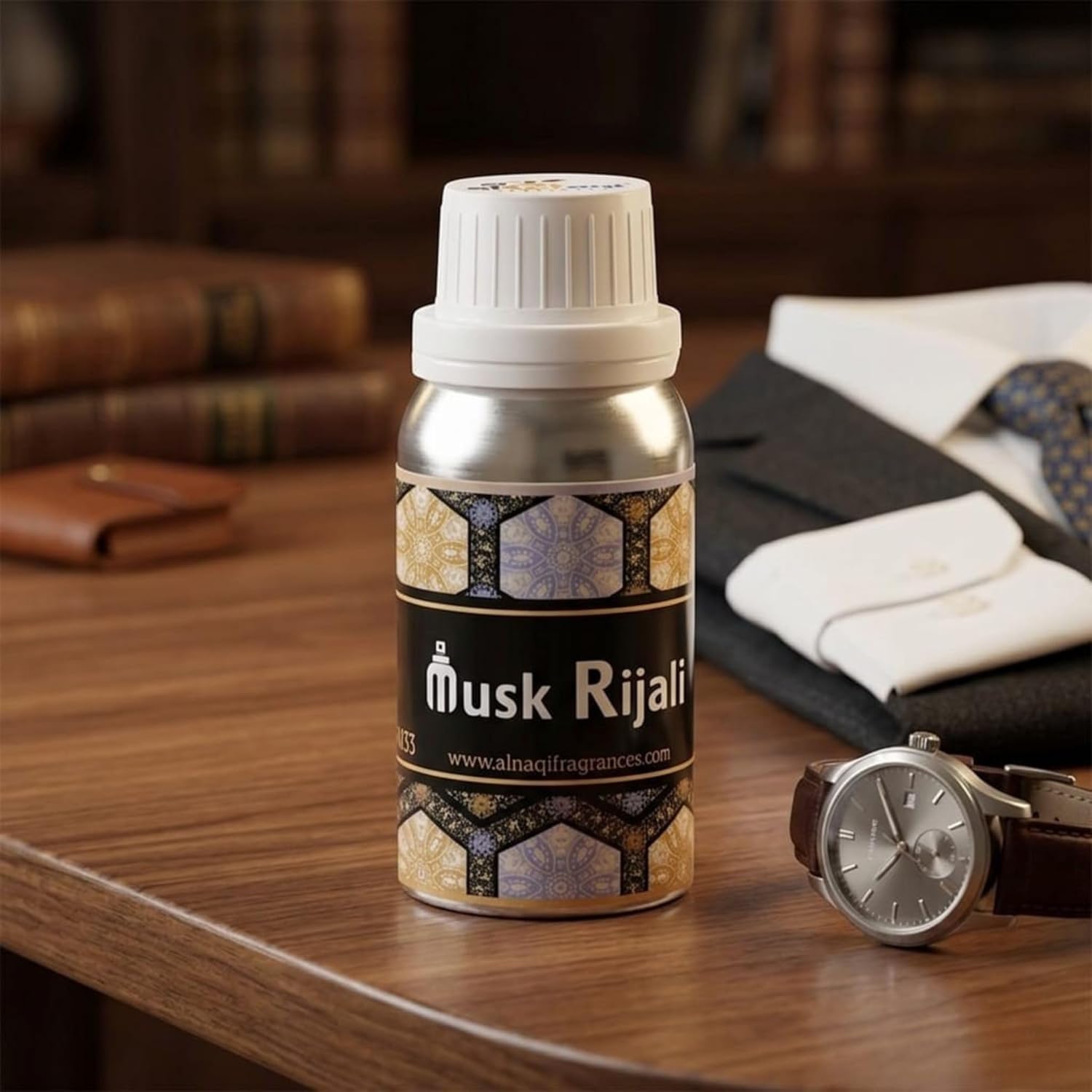 Bottle of Musk Rijali on a wooden surface with a watch and folded clothes in the background.