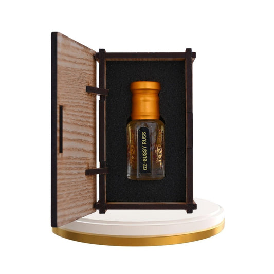 Elegant glass bottle of Alnaqi Gussy Rass Attar with intricate design.