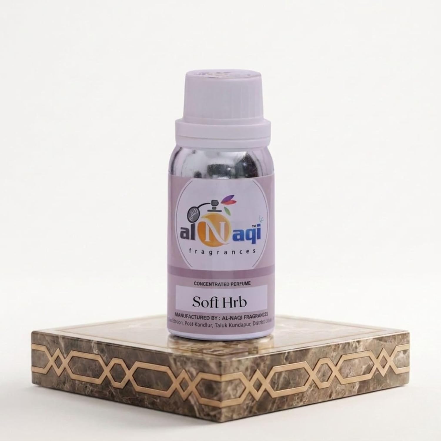 Perfume bottle labeled 'al-Naqi' on a decorative stand with a white background