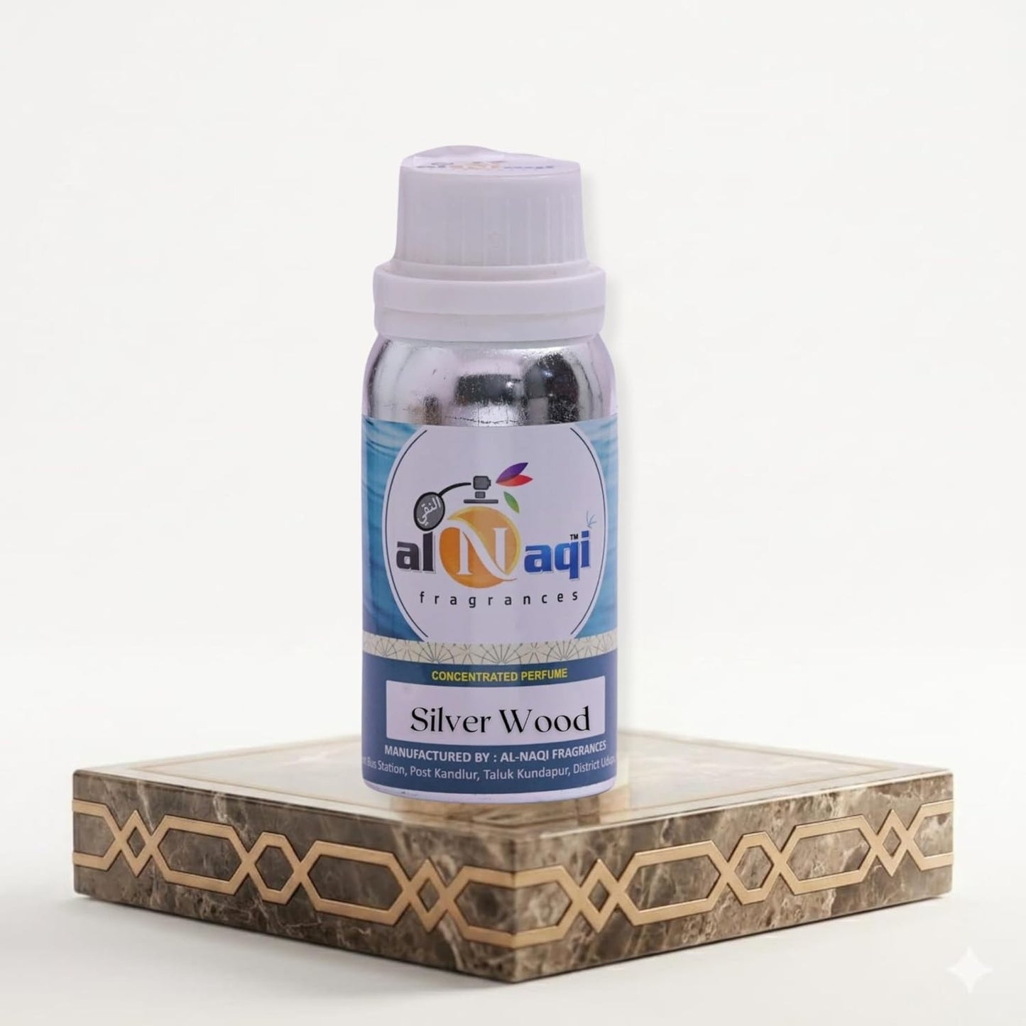 Bottle of Al-Naqi fragrances Silver Wood on a decorative stand with a white background